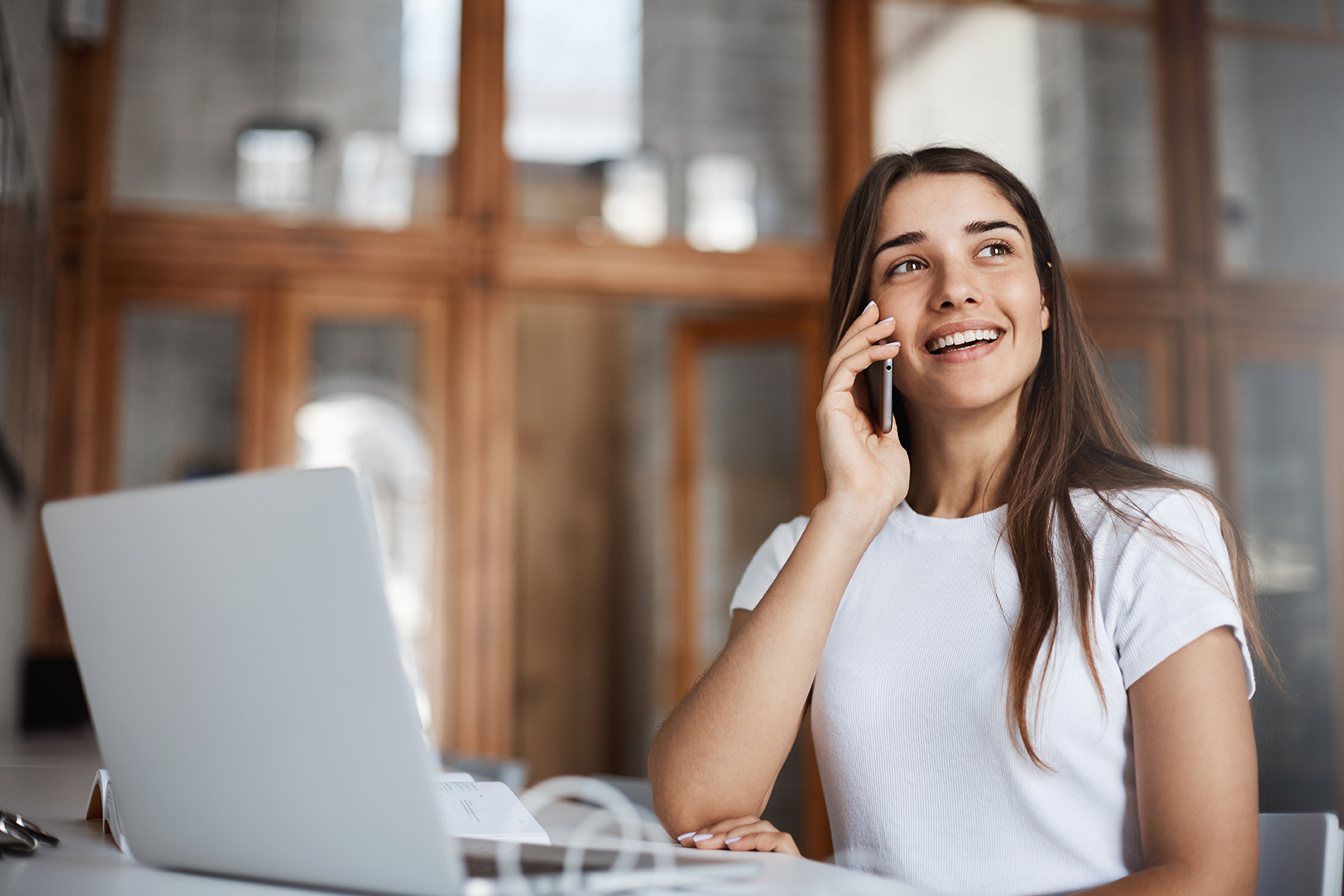 Portrait of woman talking on phone with her boyfriend smiling having fun in a public library not keeping silent.
