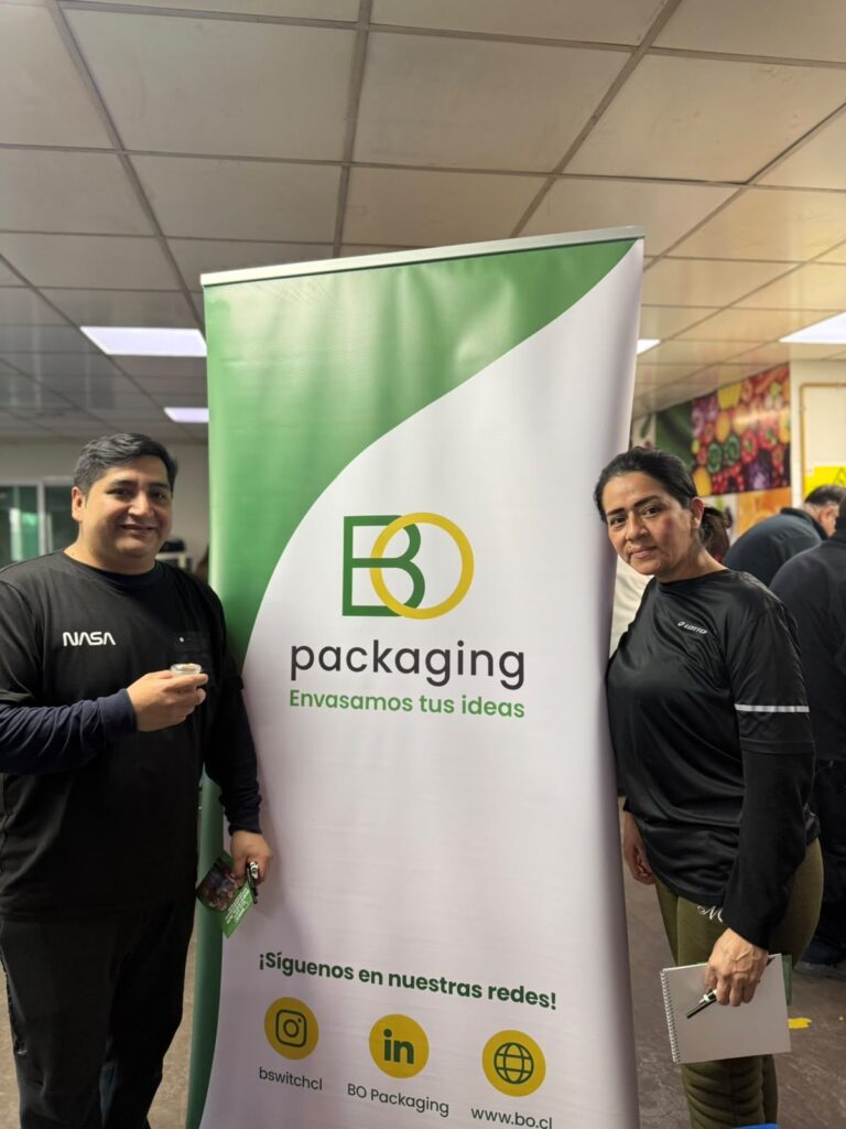 Dos asistentes junto al pendón de BO Packaging en el evento de inocuidad de DailyFoods